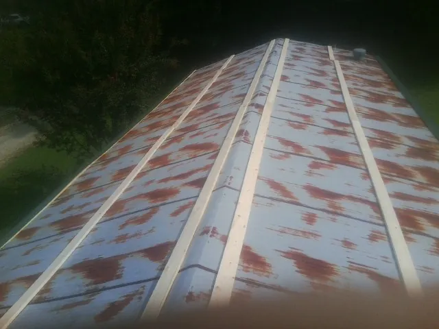 Rusted metal roof panels with new wood purlins before replacement — Storm Damage Roof Repair in Merrillville by Roofing Brothers