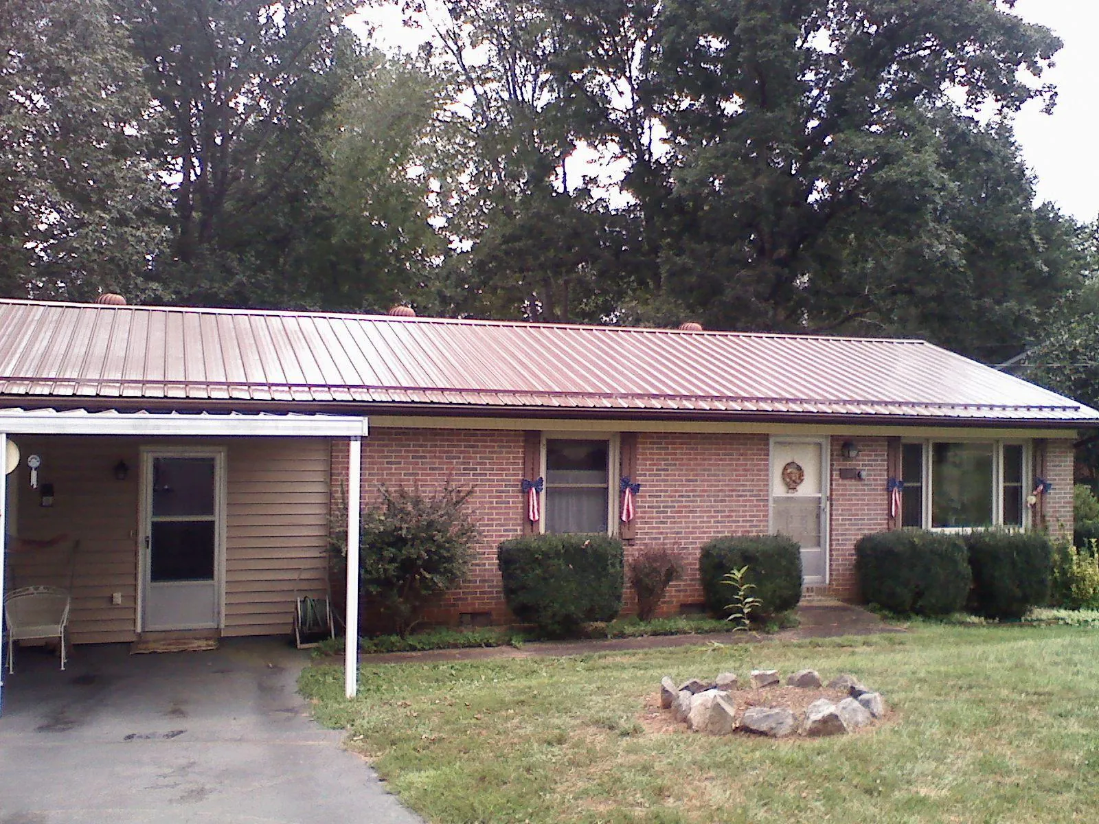 Bronze metal roof and carport on a brick ranch home — Roof Repair work by our crew in Merrillville