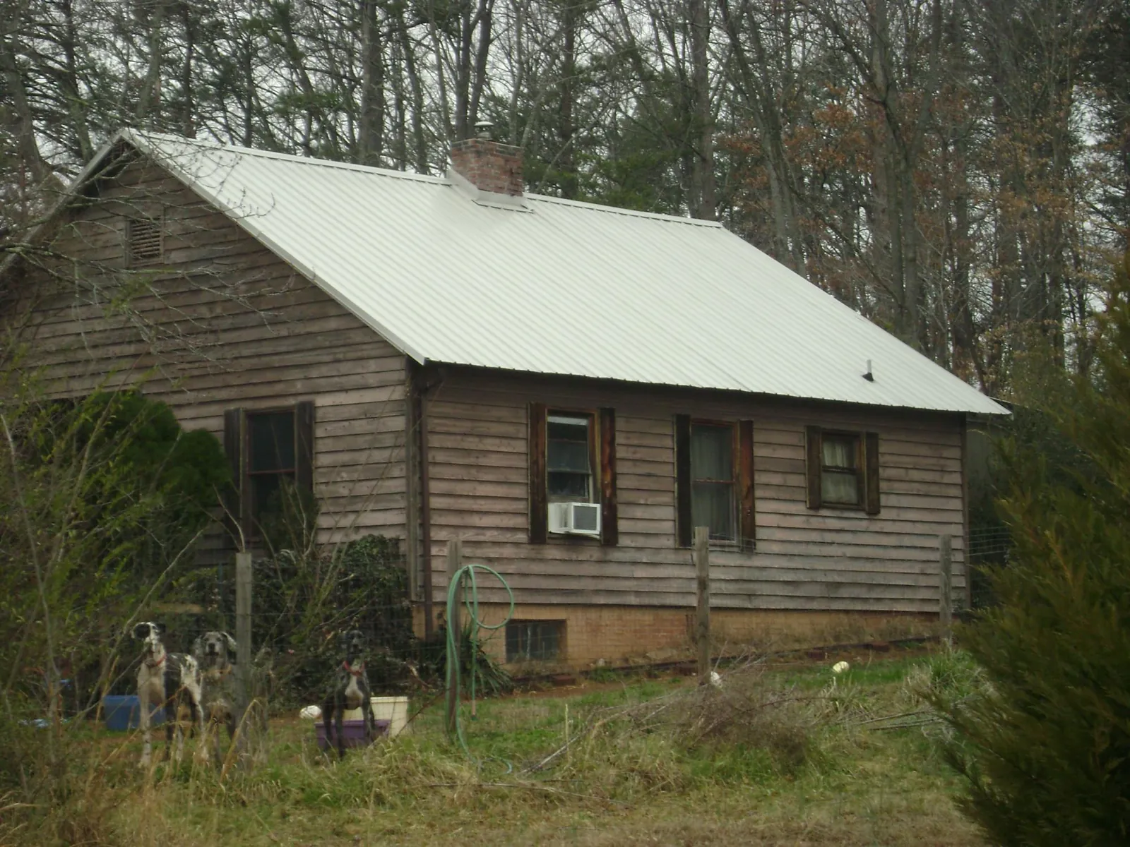 White metal roof on an old wood sided farmhouse, from a Asphalt Shingle Roof Repair job in Merrillville